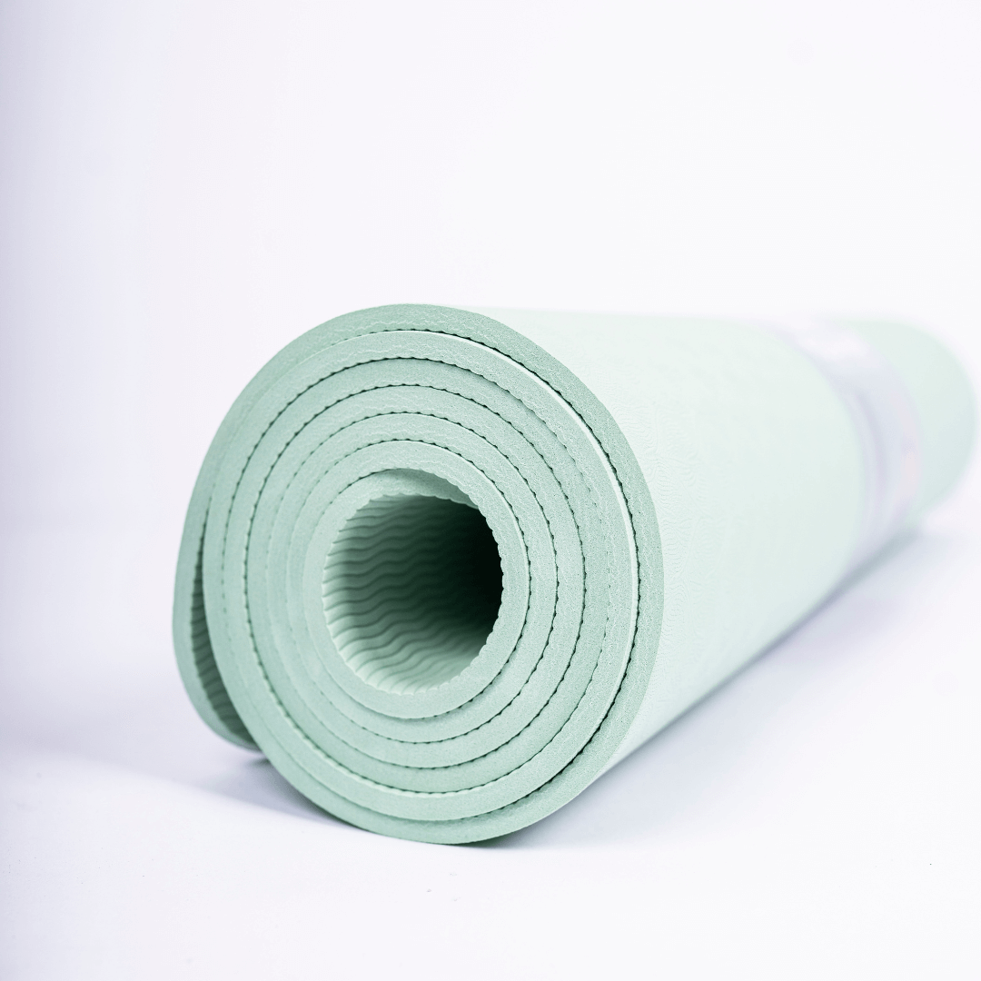 Nærbillede af Smart Makros yogamåtte i støttende og skridsikkert TPE-materiale. Miljøvenlig yogamåtte uden PVC og latex. 0,6 cm tyk måtte med blød struktur og dæmpende effekt. Yogamåtte til ledaflastning ved knæ, hofter og håndled. Komfortabel træningsmåtte til kvinder. Grønt yogaunderlag med blødt mønster og skridsikker overflade – ideel til yoga, pilates, udstrækning og hjemmetræning. Lang og fleksibel måtte til alle højder (183 cm). Yogamåtte med god støddæmpning og stabilitet. Ideel til træning i overga